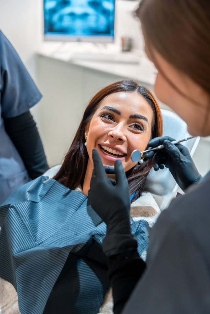 Dentist examining patient's teeth in modern dental clinic